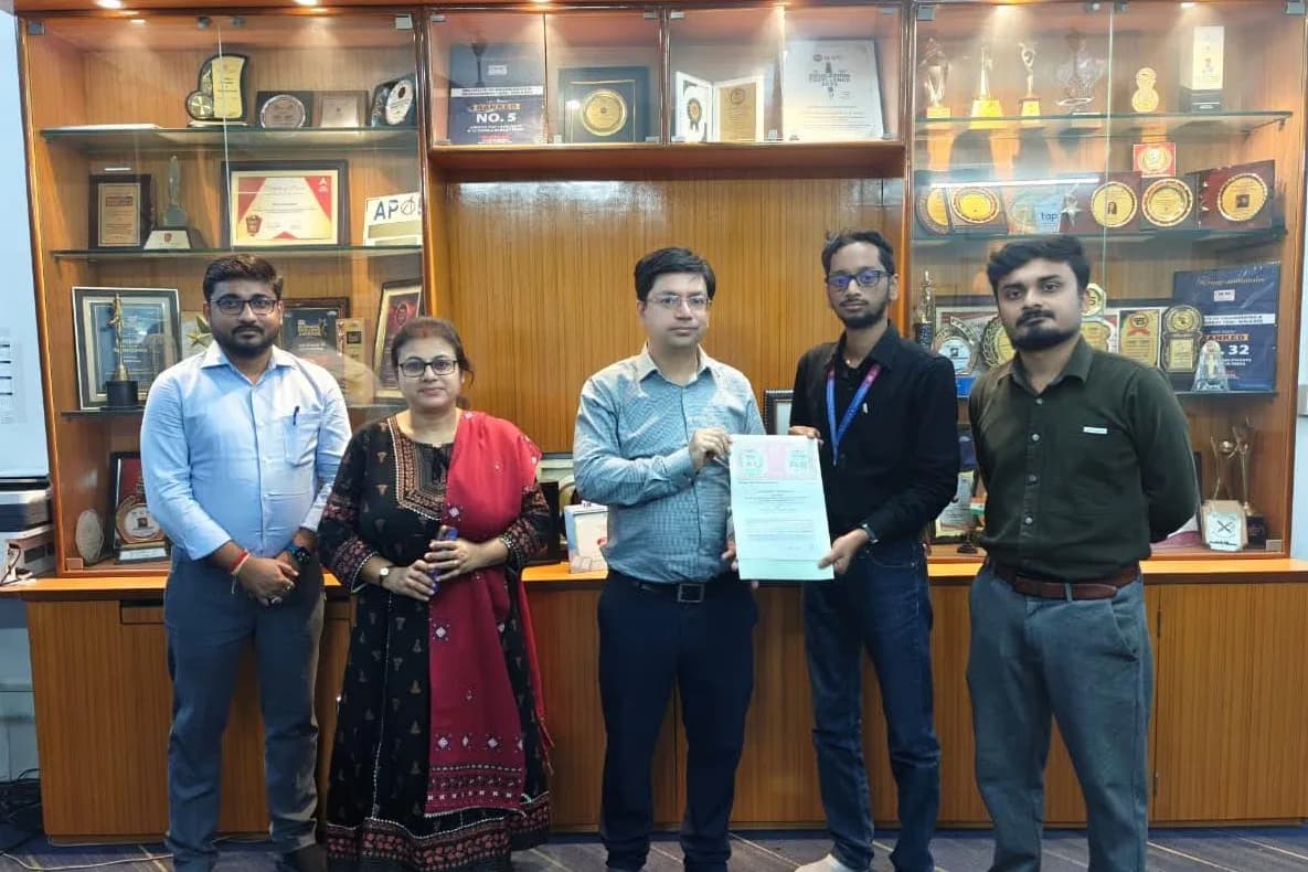 Aeonix team receiving a certificate, beside a display of trophies